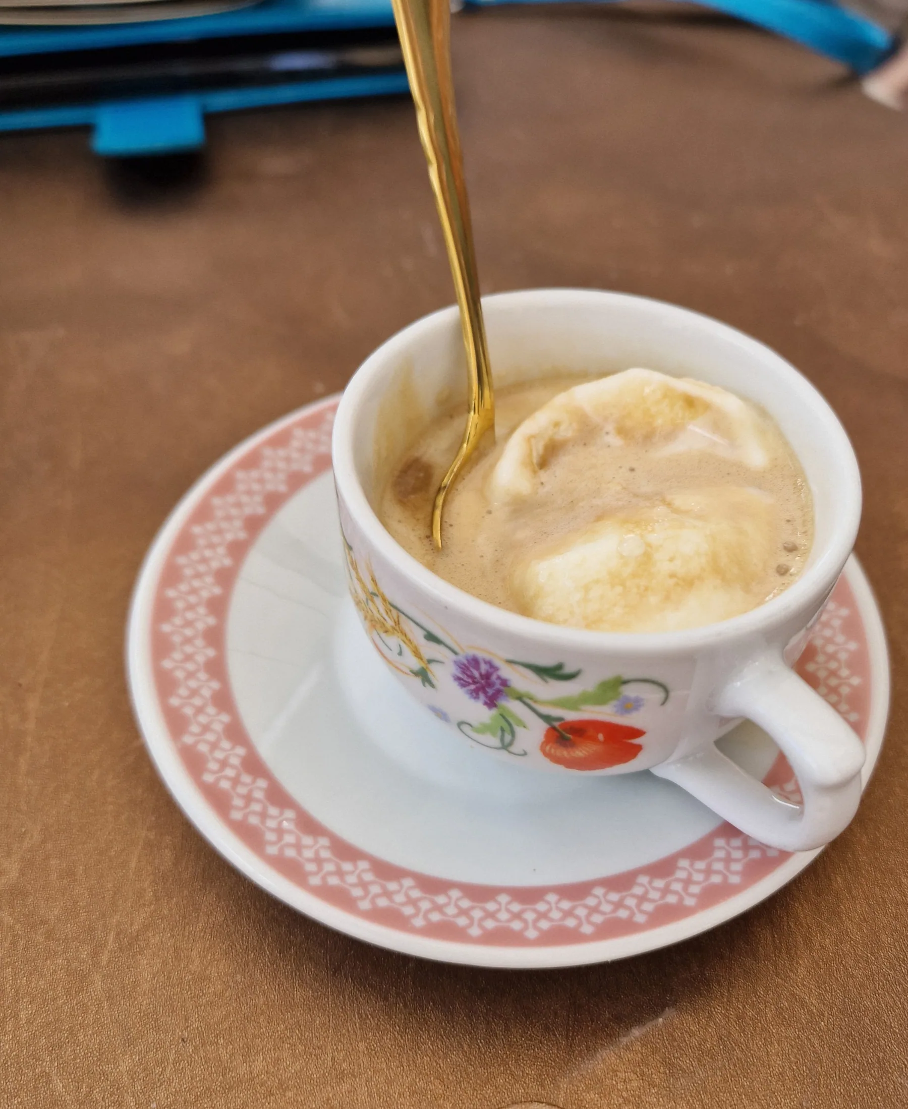 Affogato servi dans une tasse italienne avec une cuillère dorée.